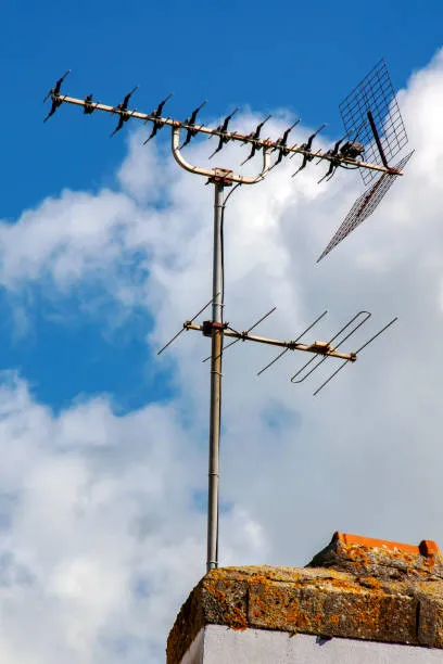 Technicien antenniste réglant une antenne TV