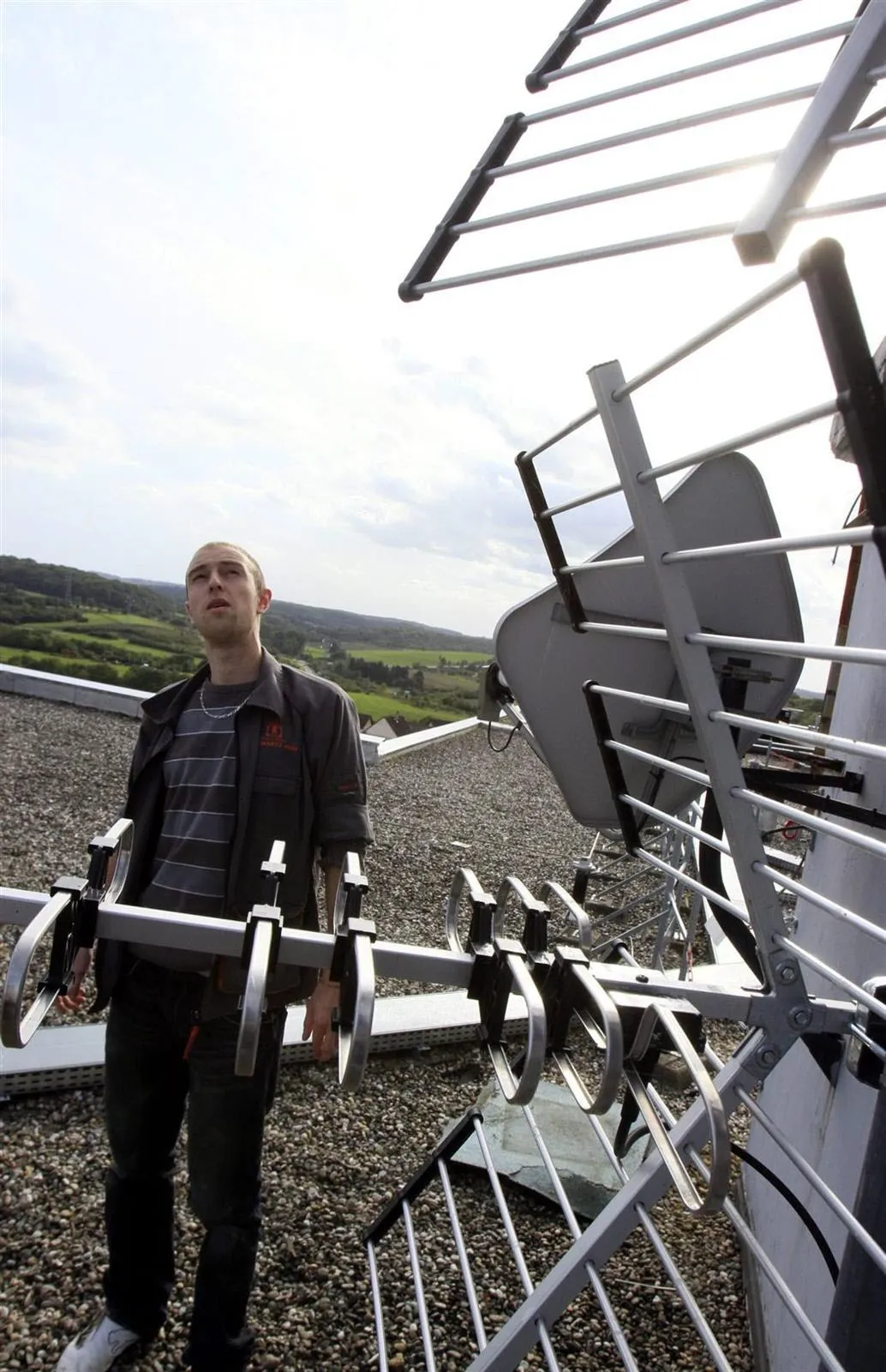 Technicien antenniste réglant une antenne TV